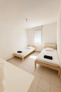 una habitación con dos camas y una ventana en 2-Bed House Sleeps 6 15 mins to Toulouse, en Fenouillet