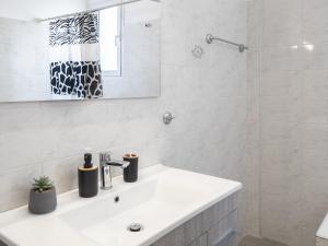 スパタにあるSunrise By Athens Airportの洗面台と鏡のある白いバスルーム +21枚の写真