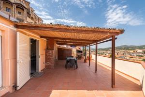 a pergola on a balcony with a table and chairs at Attico Lussu in Villasimius