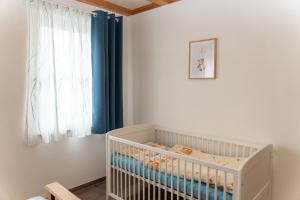 a white crib in a room with a window at Ferienwohnung Hof in Wolfach