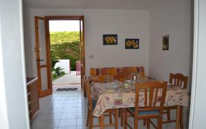 ein Esszimmer mit einem Tisch, Stühlen, einem Tisch und einer Tür in der Unterkunft Casa a Torre dell Orso Pt55 in Torre dell'Orso + 27 Fotos