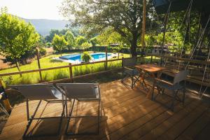 HolaCamp Vall Natura في Sant Miquel de Campmajor: سطح مع كراسي وطاولة ومسبح