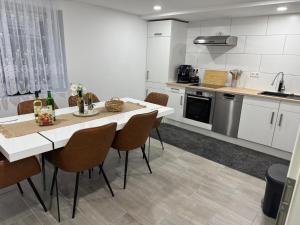 a kitchen with a table and chairs in a room at M B Homes Lauterstein 10 in Lützelalb +10 photos