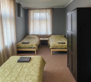 a room with two beds and a dresser in it at Objekts Guesthouse - Creative Quarter Apartment in Riga +11 photos