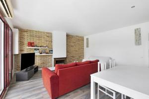 a living room with a red couch and a fireplace at Casa con piscina privada en Sitges in Sant Pere de Ribes
