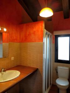 une salle de bain avec un lavabo et des toilettes et une fenêtre dans l'établissement La Casona del Silencio, à Aldehuela de Periañez