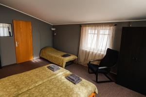 a hotel room with two beds and a chair at Objekts Guesthouse - Creative Quarter Apartment in Riga