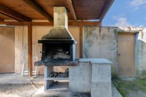 an outdoor oven is under a wooden roof at Cal Contra in Gélida