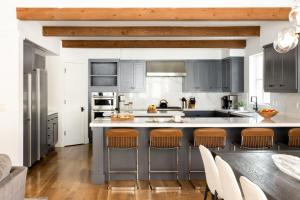 a kitchen with gray cabinets and a large island with bar stools at RMR: Granite Ridge Lodge 3197 in Teton Village in Teton Village