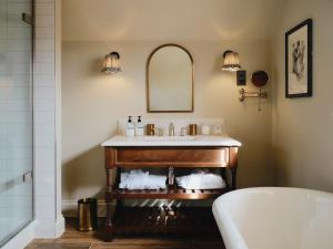 un baño con lavabo y bañera en The Swan Inn, en Fittleworth