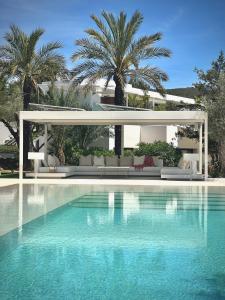 einen Pool mit einer Villa im Hintergrund in der Unterkunft Casa Tyane in Sant Jordi