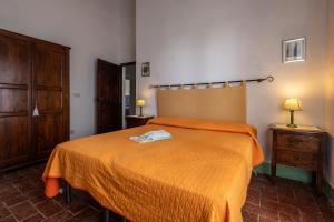 a bedroom with a bed with an orange blanket at Appartamento Lilla in Radicofani +18 photos