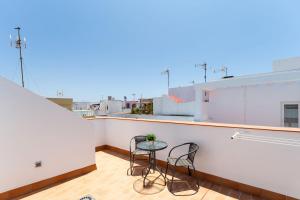 a balcony with two chairs and a table on a building at Apartamento Sol in Barbate
