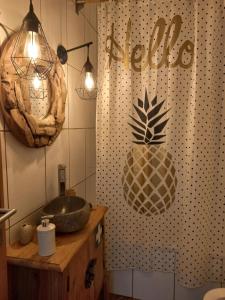 La salle de bains est pourvue d'un lavabo et d'un ananas sur le mur. dans l'établissement House Bali Furnas, à Furnas 30 autres photos