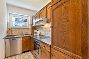 a kitchen with wooden cabinets and a sink and a dishwasher at Streck in Bad Peterstal-Griesbach