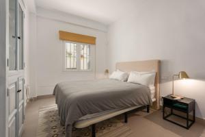 エステポナにあるVivienda Casaresのベッドと窓のある白い寝室