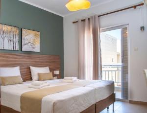 a bedroom with a large bed with a large window at Akti Luxury Rooms & Apartments in Olympiaki Akti