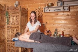 una donna seduta su un letto con la pancia incinta di La roulotte de Fichous a Fichous-Riumayou