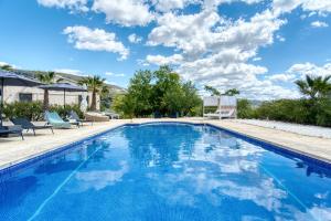 JijonaにあるCasa en Finca Rusticaの青い水とヤシの木が茂るスイミングプール