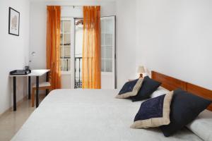 een slaapkamer met een groot bed en een bureau bij Meraki Nerja in Nerja