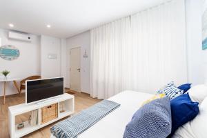 a bedroom with a bed with a flat screen tv at Apartamento Luna in Barbate