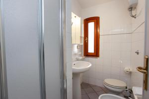 une salle de bain avec un lavabo, des toilettes et un miroir dans l'établissement La Casa di Barbara, à Siniscola