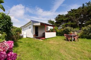 ein kleines weißes Haus mit einem Tisch im Hof in der Unterkunft Chalet face mer Pointe Saint Gildas in Préfailles
