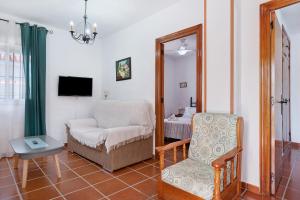 een woonkamer met een stoel en een spiegel bij Casa Antonia 2 in Conil de la Frontera