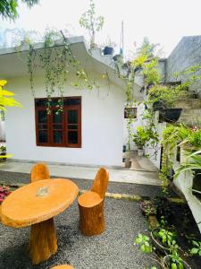 a wooden table and two chairs in front of a house at Lakru Home Stay in Weligama