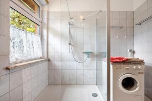 a bathroom with a shower and a washing machine at Ferienhaus Feldblick in Karwitz +19 photos