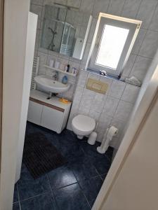 ein kleines Badezimmer mit Toilette und Waschbecken in der Unterkunft Ferienwohnung Kleve Kellen in Kleve + 6 Fotos