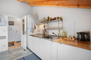 a kitchen with white cabinets and a sink at Place In The Bavarian Mountains in Schneizlreuth