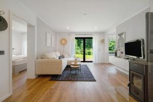 a living room with a couch and a tv at Design-Apartment mit Garten in Langenbach