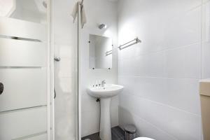 um banheiro branco com pia e chuveiro em A Cerca - C em Lagos mais 15 fotografias