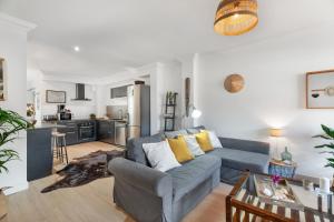 a living room with a blue couch and a kitchen at La casa de los viajeros in Punta del Hidalgo +17 photos