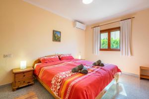 a bedroom with a large bed with red sheets and a window at Casa Mediterranea in Cala Santanyi