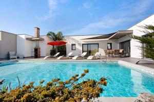 a swimming pool with chairs and a house at Villa Colina in Salir de Matos