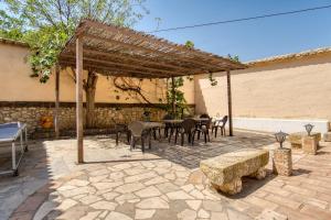 a patio with tables and chairs and a wooden pergola at Madara in Monóvar