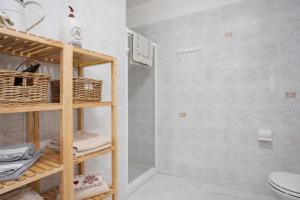 ein Badezimmer mit einem WC und einem Regal mit Handtüchern in der Unterkunft Casa Hueller Roncegno in Rundscheinberg + 20 Fotos