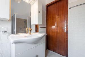 a bathroom with a sink and a wooden door at Villetta Luisa in Villa San Pietro +19 photos