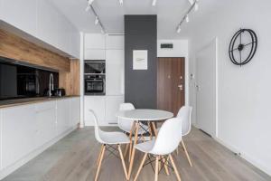 cocina con mesa y sillas blancas en una habitación en Exclusive Apartments on Kasprzaka Street - Warsaw Wola, en Varsovia 3 fotos más