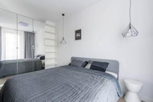 Un dormitorio con una cama grande y un espejo. en Exclusive Apartments on Kasprzaka Street - Warsaw Wola, en Varsovia