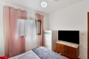 バルセキージョにあるVilla Alejoのベッドルーム(ベッド1台、ドレッサー内のテレビ付)