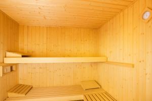 a wooden sauna with two shelves and a clock at Hotiday Vieste Centro in Vieste
