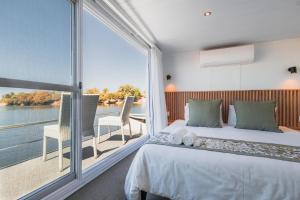 a bedroom with a bed and a large window at Chobe Princess by Mantis in Kasika
