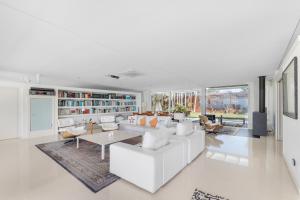 a living room with white furniture and large windows at Casa Nirvana - Penthouse in Sitges