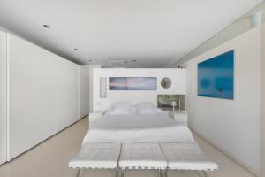 a bedroom with white walls and a large bed at Casa Nirvana - Penthouse in Sitges +29 photos