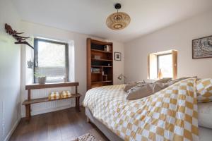 a bedroom with a bed with a checkered blanket at Charming Gîte Le 1681 Xl in Chaumousey