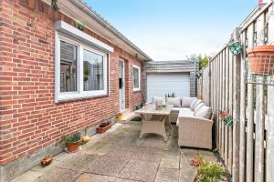 a patio with a couch and a table on a brick building at Bungalow vor Sylt in Diedersbüll