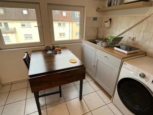 cocina con mesa y lavadora en Cozy Room close to station, en Stuttgart